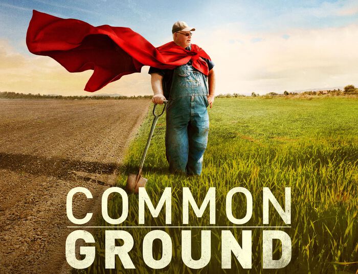 En plakat med en bonde som står lent på en spade ute på et jorde og teksten "commond ground" i stor skrift. 