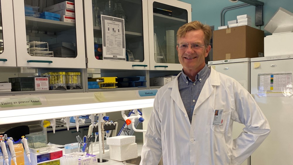 Image shows a man with glasses in a lab coat
