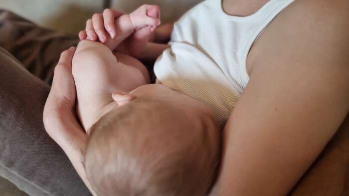 Image shows a woman breastfeeding her baby