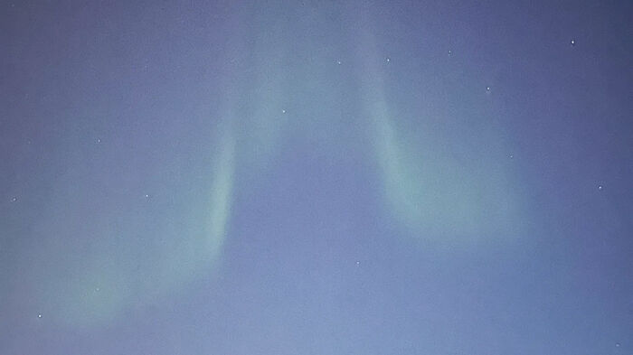 Aurora Borealis or the Northern light in green streaks over the night sky