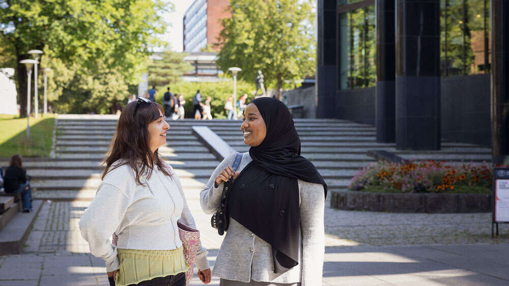 Two students in conversation outside the University Library