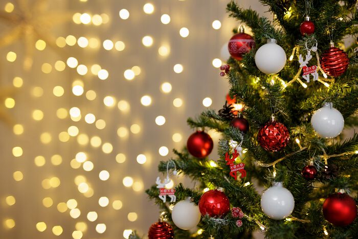 A decorated Christmas tree with ornaments and lights in the background.