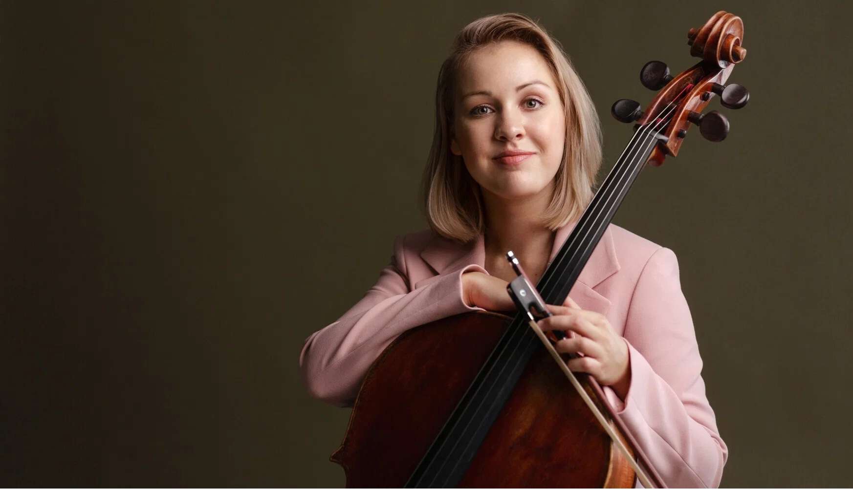 En smilende kvinne med cello.