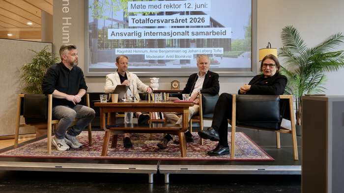 Bilde av de fire som var på scenen, inkludert moderator