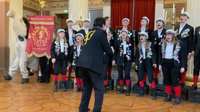 Bilde av koret Corpsus Juris når de fremfører musikkstykke i Gamle Festsal.