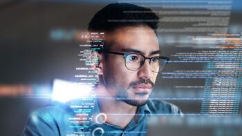 Picture of a man looking at a screen and som blurred text in the background