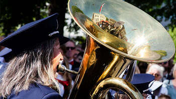 Bilde av korps og en kvinne som spiller tuba på nasjonaldagen