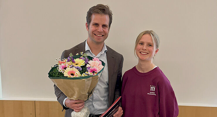 Mann står med blomster og pris sammen med en ung dame.