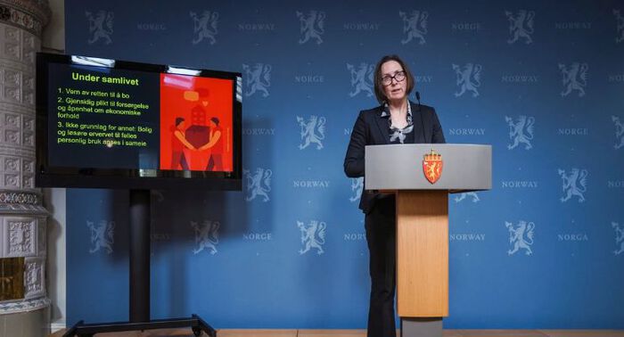 Dame står på scene og holder pressekonferanse.