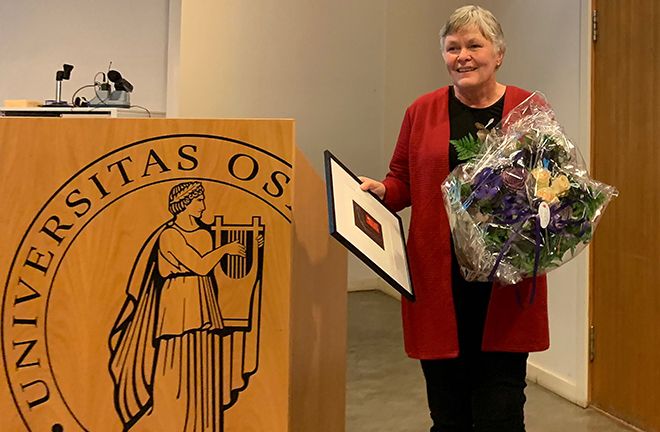 Nina K. Vøllestad blir takket av som instituttleder med blomster og bilde