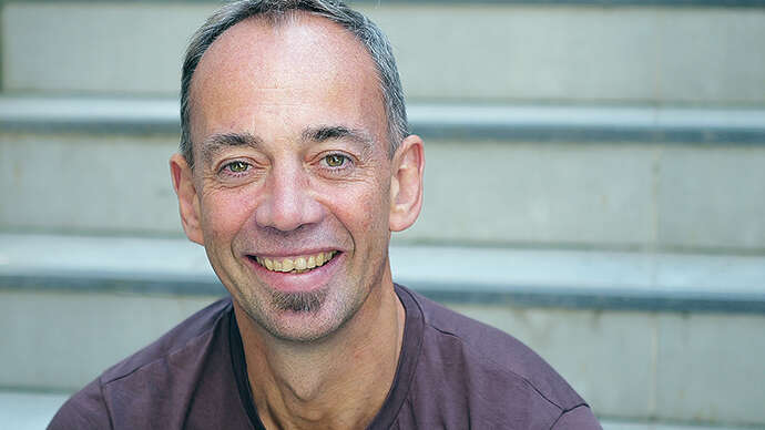 Professor Malcolm Langford sittende i en trapp.