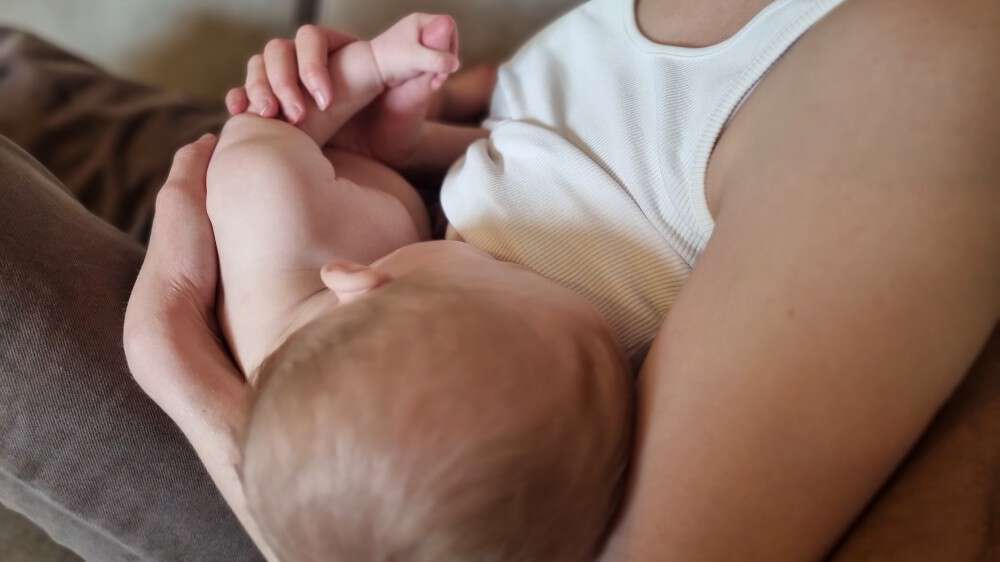 Bildet viser en kvinne som ammer en baby
