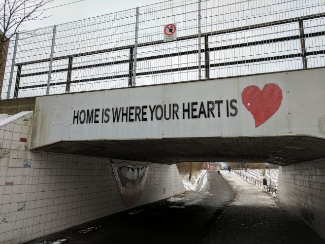 Home is where your heart is står det på en bro. Foto.
