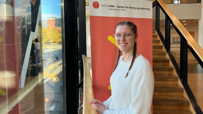 Bildet av studenten Iris som er i praksisopphold ved LINK ved trappeoppgangen til senteret