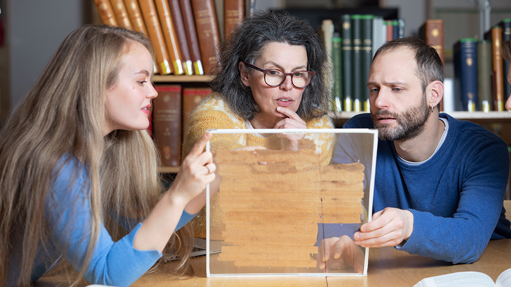 Forskere ved UiO som studerer gammelt manuskript