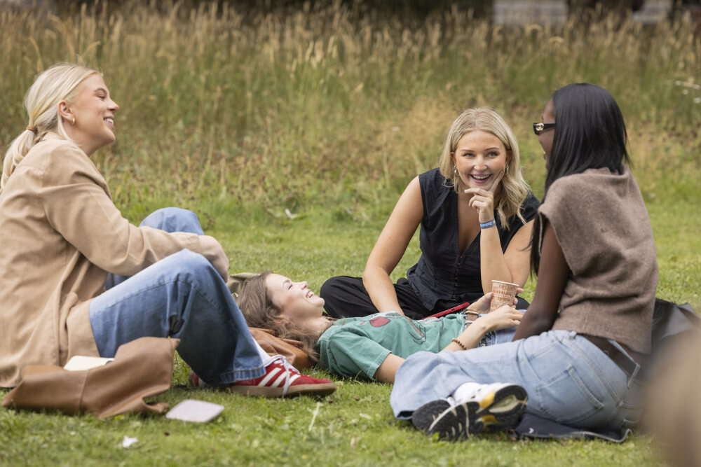 Bildet kan inneholde: mennesker, lykke, gress, bukse, sitter.