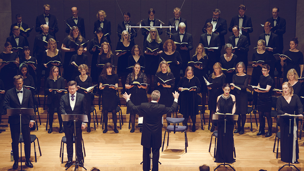 Akademisk korforening som holder konsert med sangsolister og dirigent i front