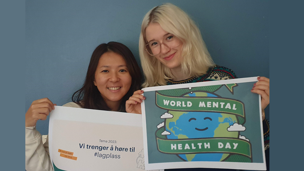 Two young women holding up posters with text: World mental health day. 