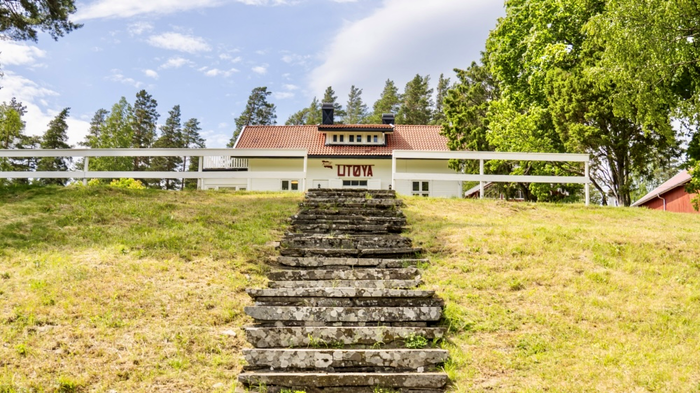 Bilde av hovedbygningen på hovedøya. Forgrunnen viser en lang og bratt steintrapp opp mot bygningen.