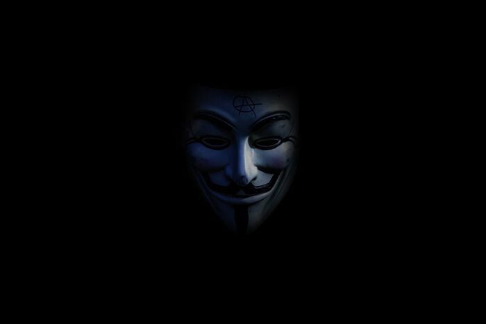 Guy Fawkes-maske i mørket. Slike masker brukes ofte av hackergruppen Anonymous.