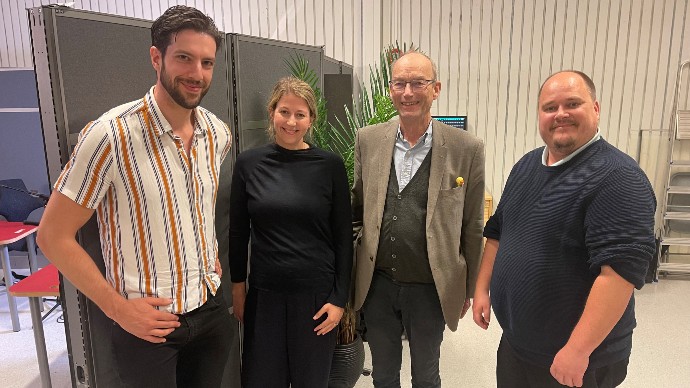 Bilde av fire mennesker (tre menn og en kvinne) som ser mot kamera