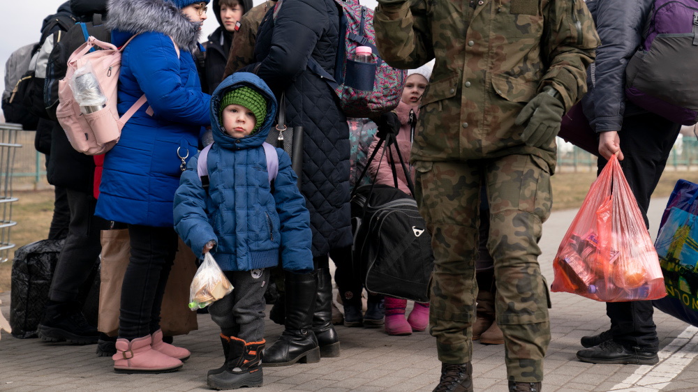 Fyktninger på grensen kellom Ukraina og Polen. En liten gutt ser inn i kameraet