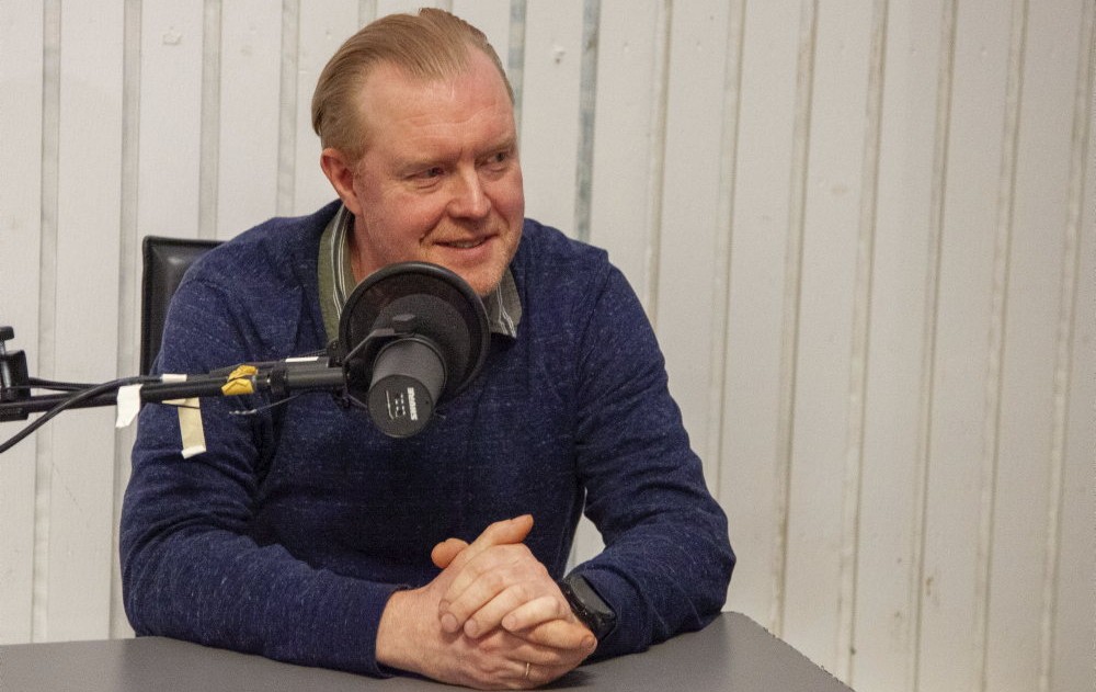 Kåre-Olav Stensløkken sitter bak mikrofonen i podkaststudioet.