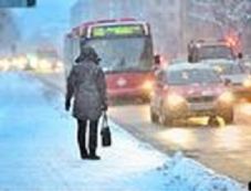 Person som venter på buss i lett snøvær