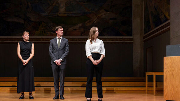 Three researchers receiving awards on a stage