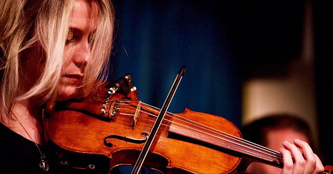 Woman playing the violin in deep concentration