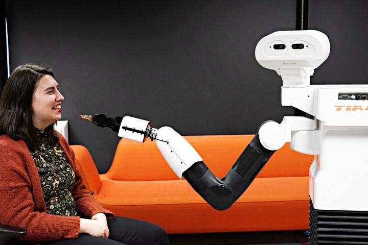 Robot prøver å ta på leppestift på forskeren.