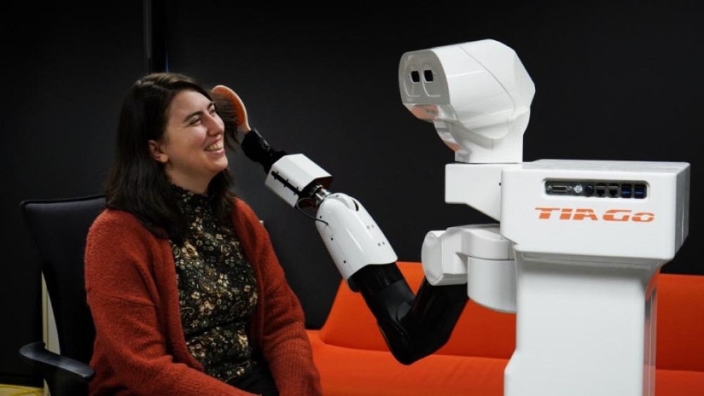 A robot brushes the hair of a researcher