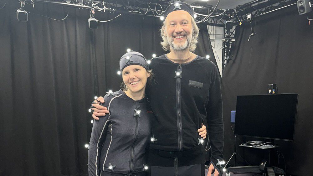 Karolina and Adam wearing motion capture suits in a motion capture lab