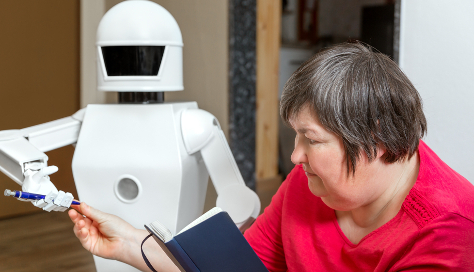 En hvit robot og en kvinne som justerer den. Foto.