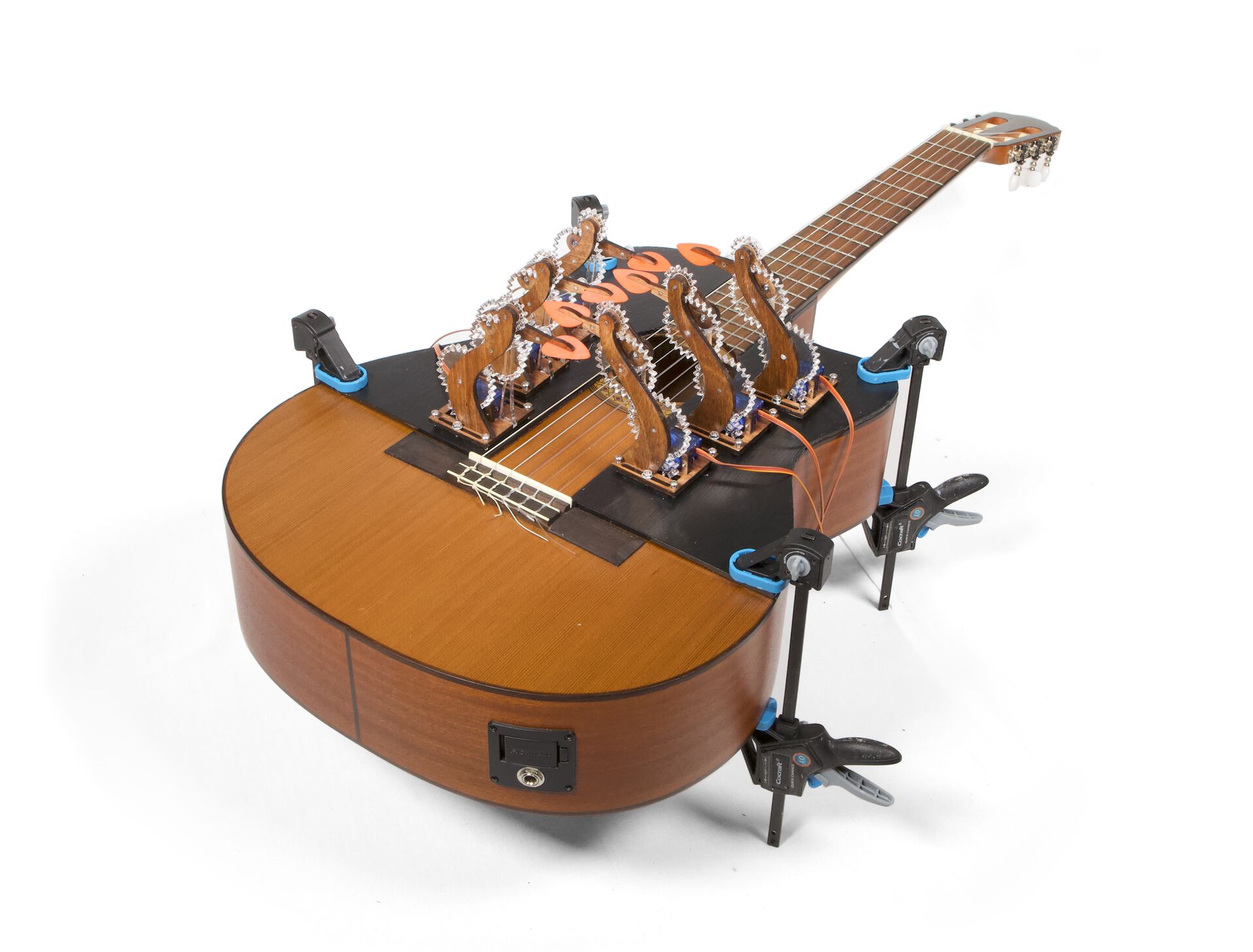 Image of a classical guitar equipped with some fancy-looking plucking mechanisms.