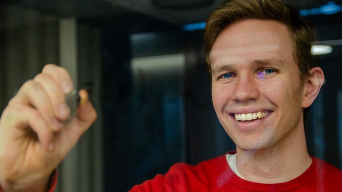 Mann smilende gjennom vindu