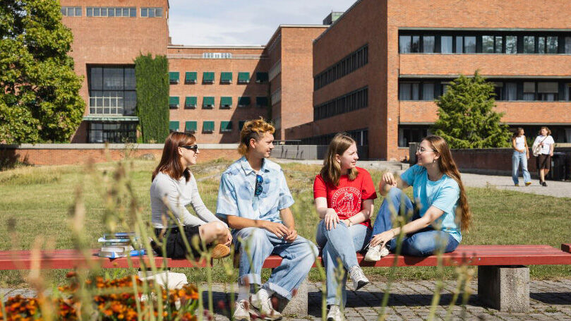 En gruppe med fem studenter og trær i bakgrunnen