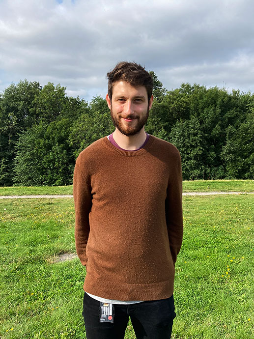 Foto av Daniel på en eng i solskinn