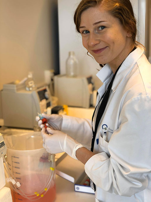 Bildet kan inneholde: smil, sikkerhetshanske, forsker, hvit kåpe, drikkevarer.
