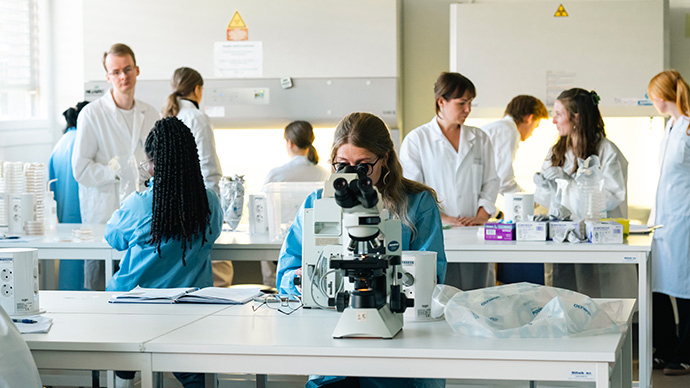 En gruppe studenter i verneutstyr på lab