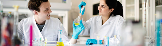 to forskere i labfrakk i et laboratorium