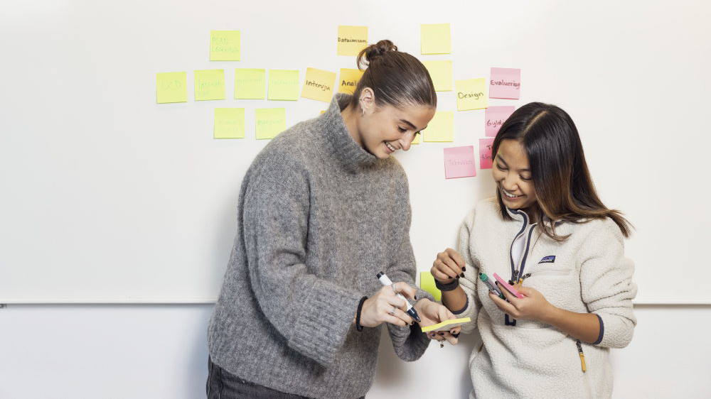 To studenter som skriver på post-it-lapper