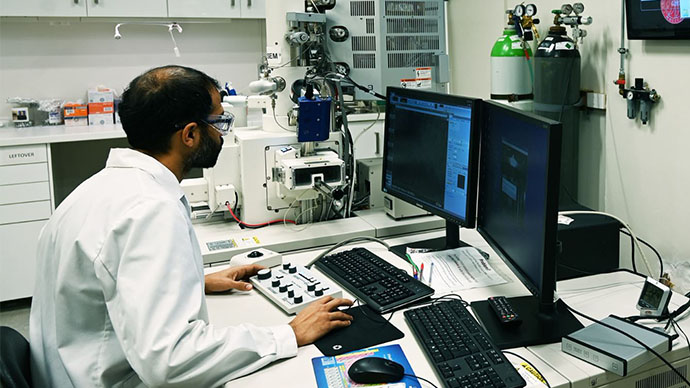 Bildet av mann i labfrakk foran datamaskin
