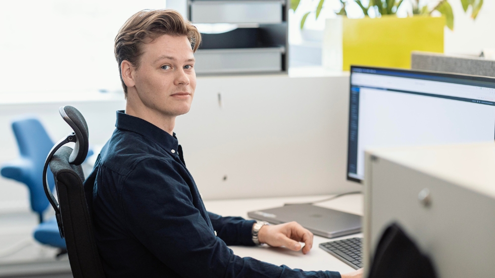 Christian sitter foran PC på kontoret. 