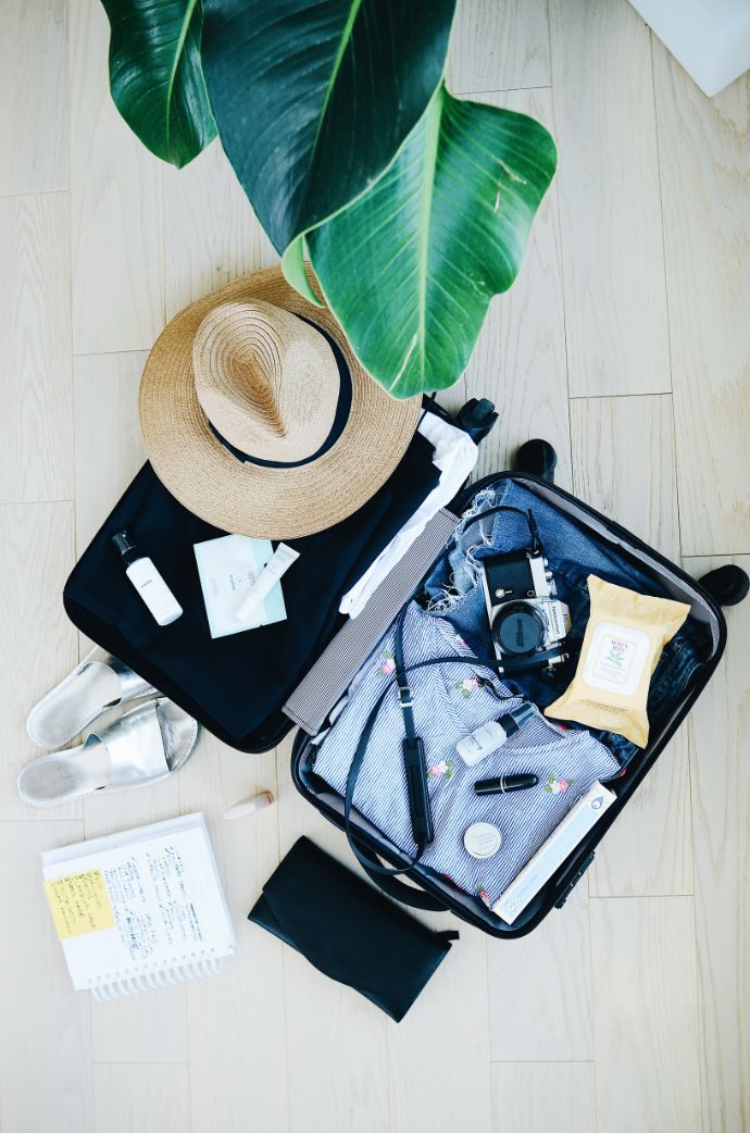 åpen koffert, solhatt, klær
