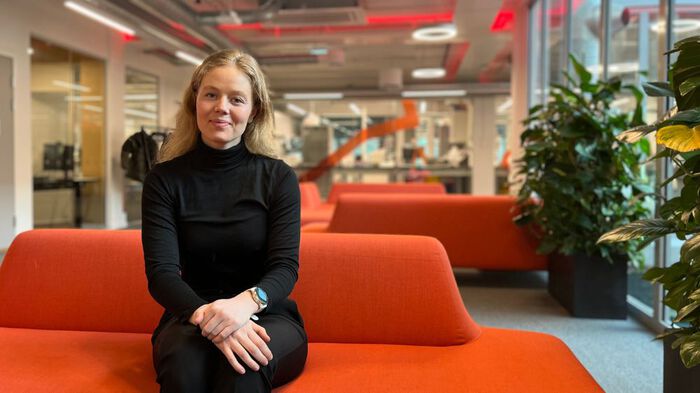 Blond kvinne i rød sofa