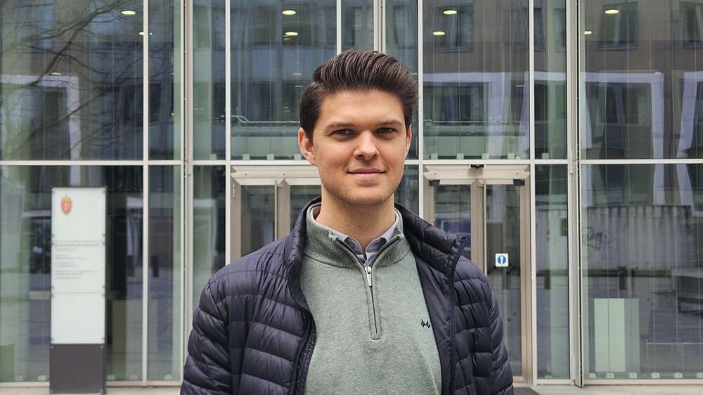 Mann som smiler utenfor bygget til Helse- og omsorgsdepartementet