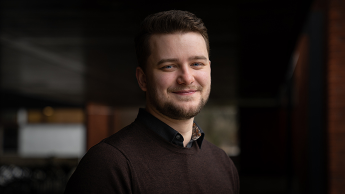Thomas som smiler, SV-bygget uklart i bakgrunnen
