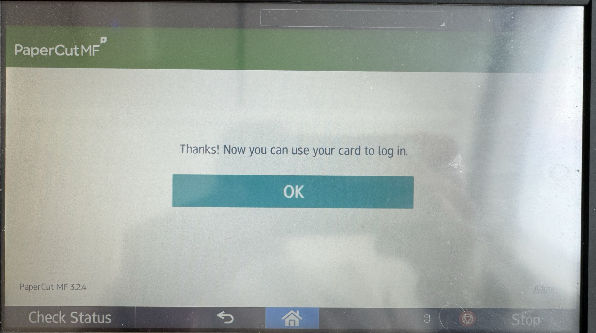 Image of the screen of a printer, with information that the card can be used to log in, and a button saying "OK"